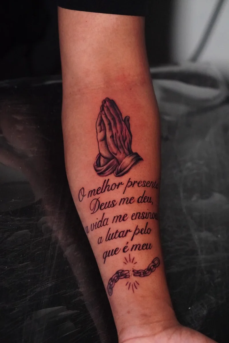 Tatuagem de mãos em oração e lettering Palivo Tattoo